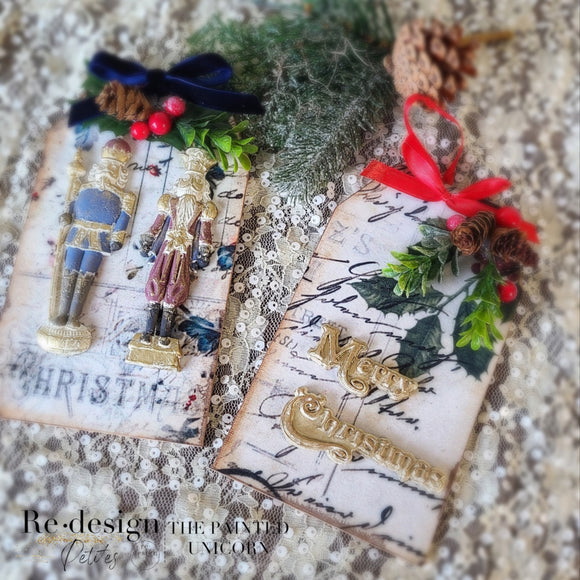 Two Christmas themed gift tags created by using ReDesign with Prima's Christmas Chipboard Tags also feature ReDesign with Prima's Twinkle Paws and Nutcracker Magic silicone mold castings.