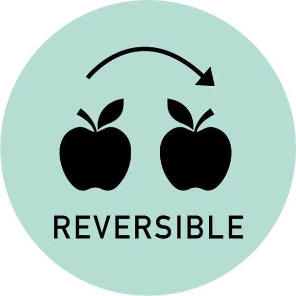 A mint green circle against a white background has 2 black apples that are mirrored to each other. Above the apples is an arched arrow pointing to the right; under the apples reads: Reversible.