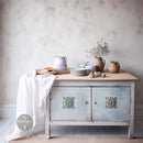 A small kitchen island table features ReDesign with Prima's Deco Accent Decor Poly bendable furniture applique in the center of each of its 2 doors.