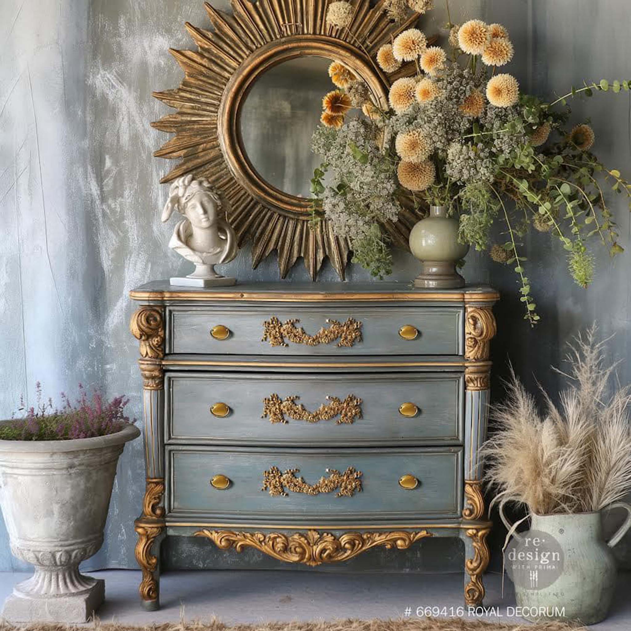 A vintage 3-drawer dresser is painted gray with gold accents and features ReDesign with Prima's Royal Decor Poly Casting in the center of the drawers.