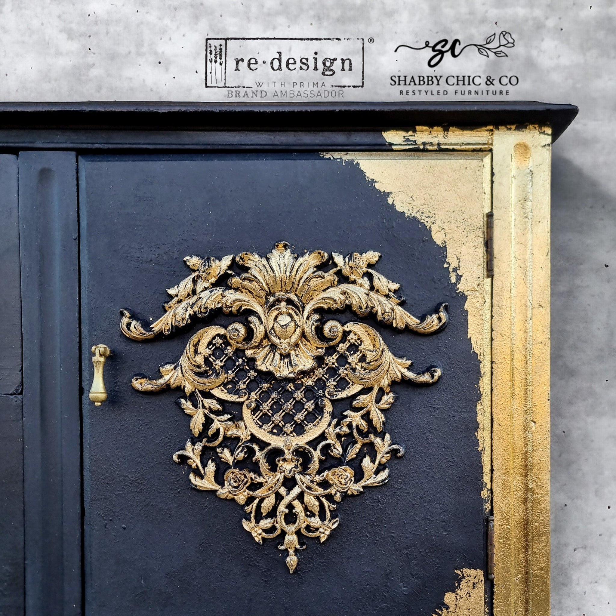 A close-up of a vintage console table refurbished by Shabby Chic & Company is painted black with gold accents and features ReDesign with Prima's Baroque Elegance Decor Poly painted gold on its 2 doors.