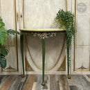 Decorative console table with gold accents against a marble wall.