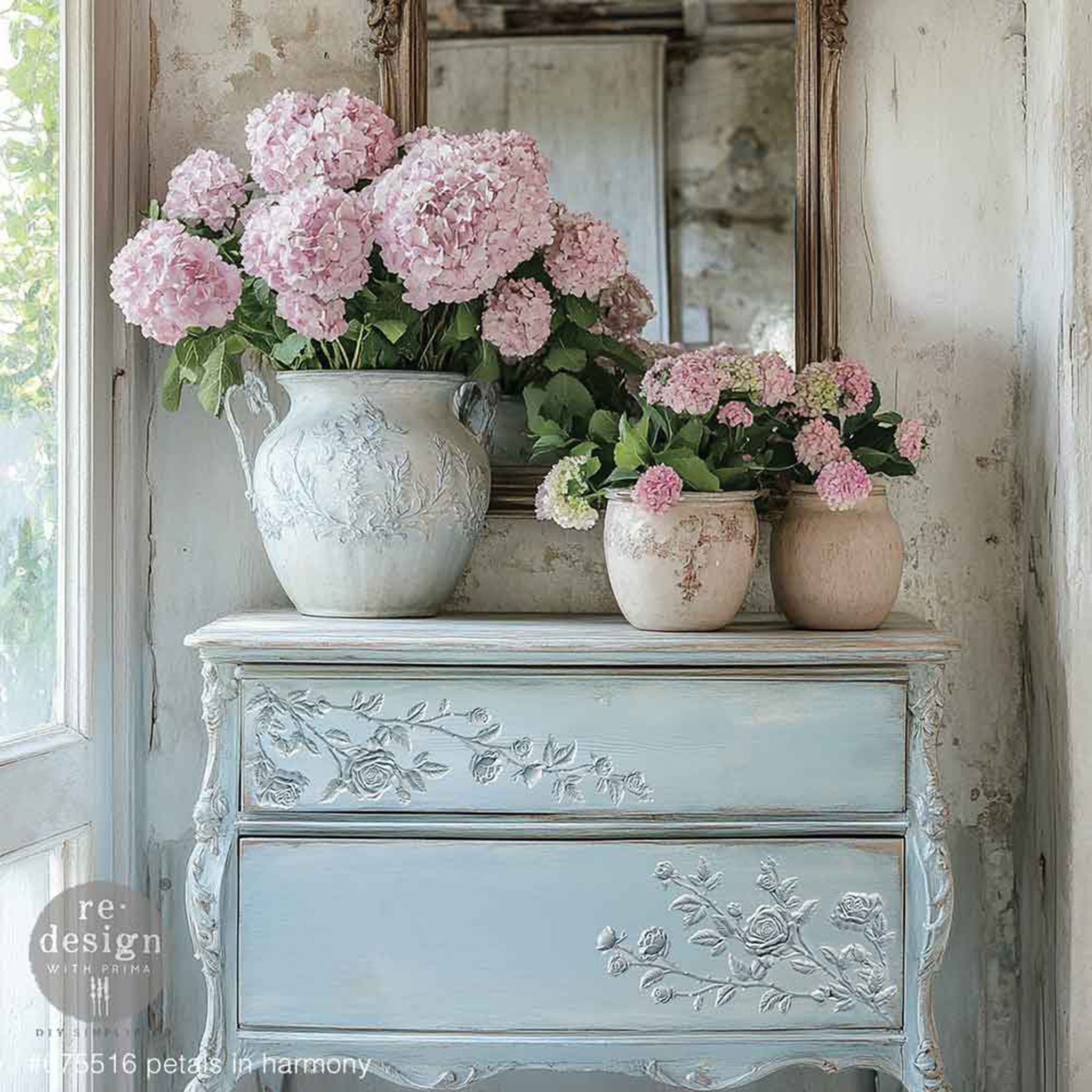 A vintage 2-drawer nightstand is painted pale blue and features ReDesign with Prima's Petals in Harmony Decor Poly bendable furniture appliques on the drawers.