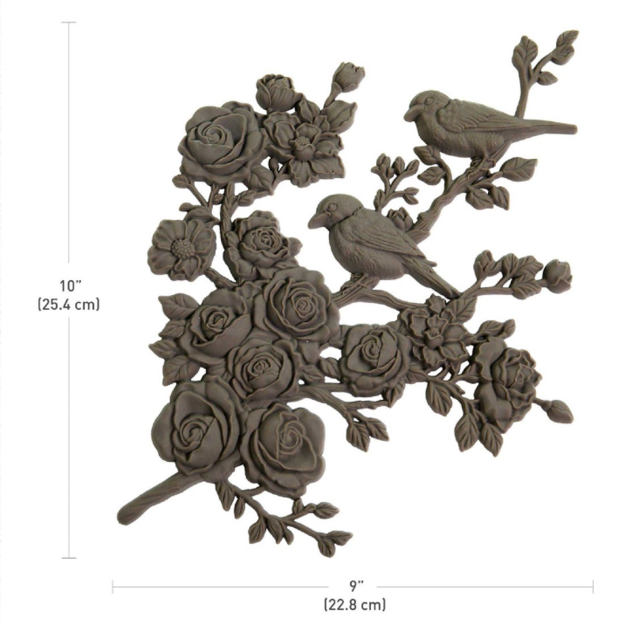 A brown colored bendable furniture applique of 2 birds perched on a branch of blooming roses and flowers is against a white background. Measurements for the applique read: 10" (25.4 cm) x 9" (22.8 cm).