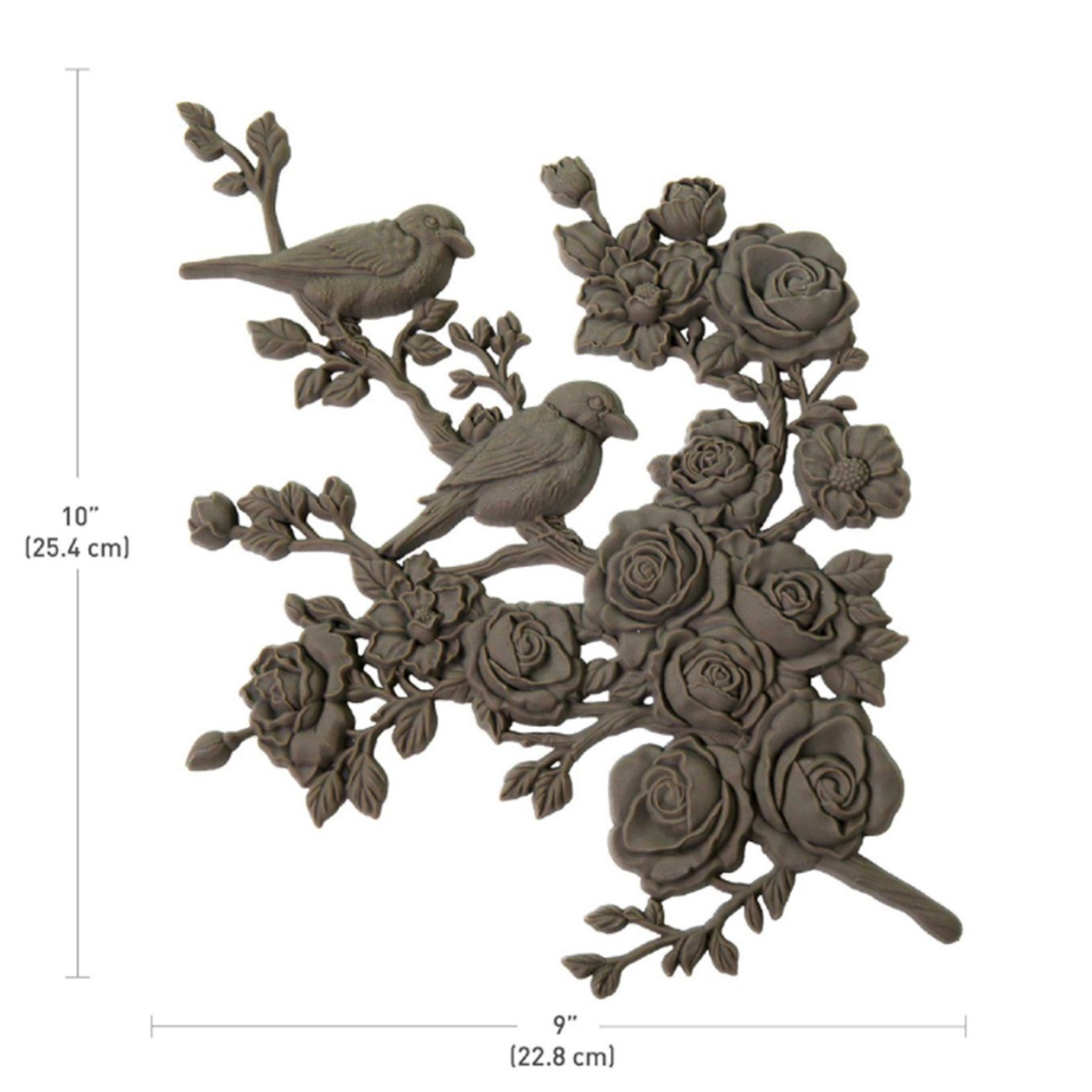 A brown colored bendable furniture applique of 2 birds perched on a branch of blooming roses and flowers is against a white background. Measurements for the applique read: 10" (25.4 cm) x 9" (22.8 cm).