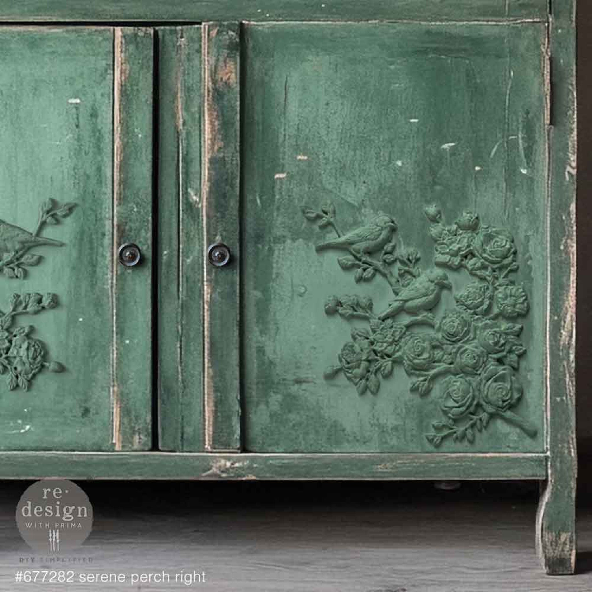 A close-up of a vintage country hutch cabinet is painted green and features ReDesign with Prima's Serene Perch (Right) on its right cabinet door.