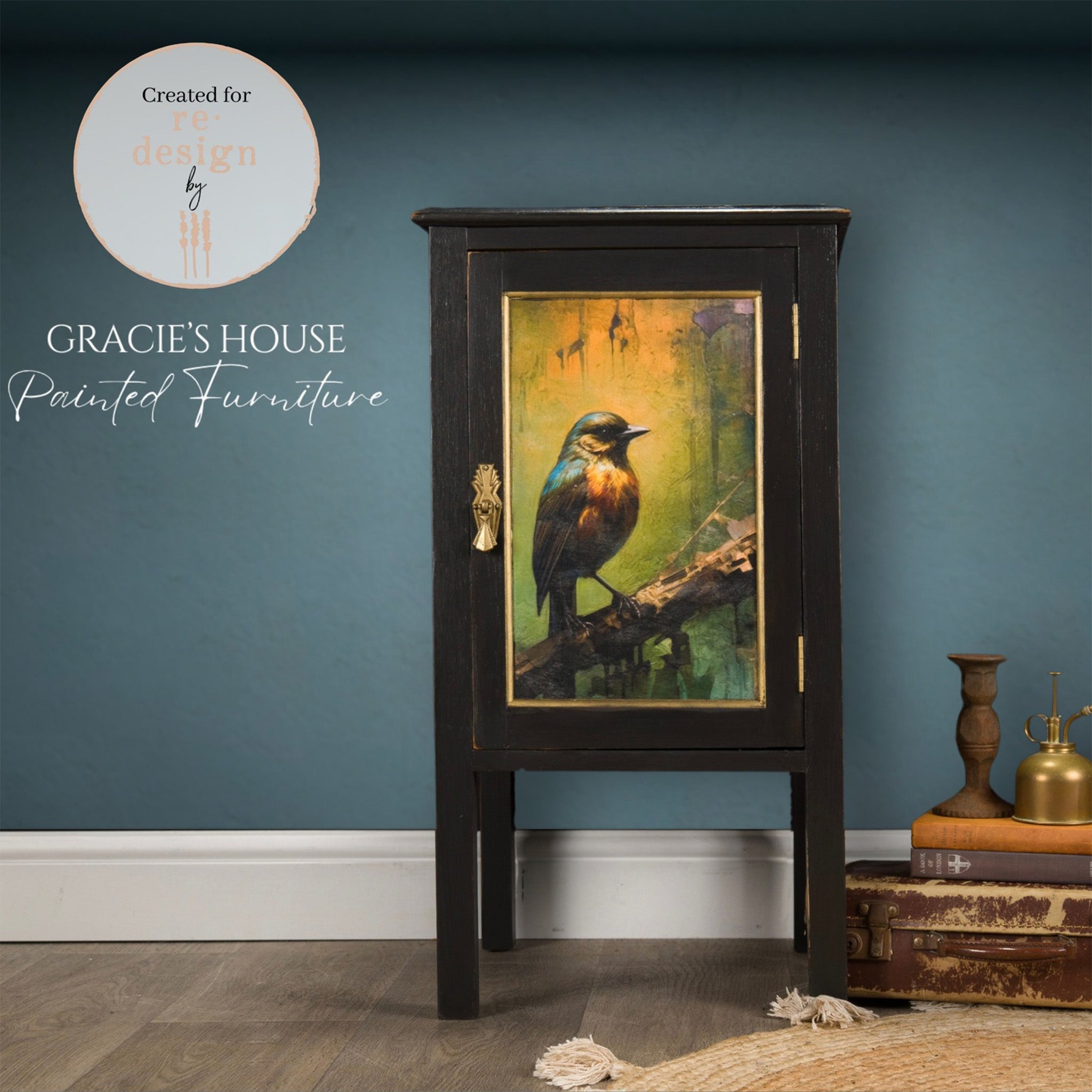 A vintage side table with storage refurbished by Gracie's House Painted Furniture is painted black and features a design from  ReDesign with Prima's Avian Dreamscape A3 fiber paper on the door.