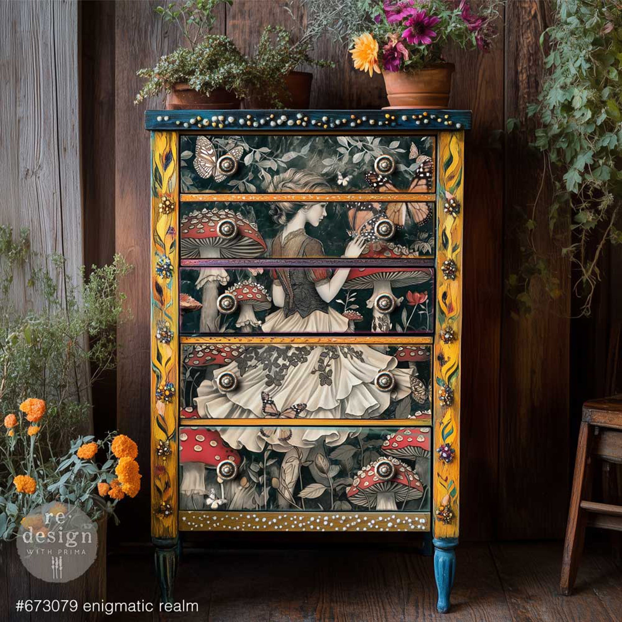 A 5-drawer chest dresser is painted mustard yellow and blue and features ReDesign with Prima's Enigmatic Realm A1 fiber paper on its drawers.