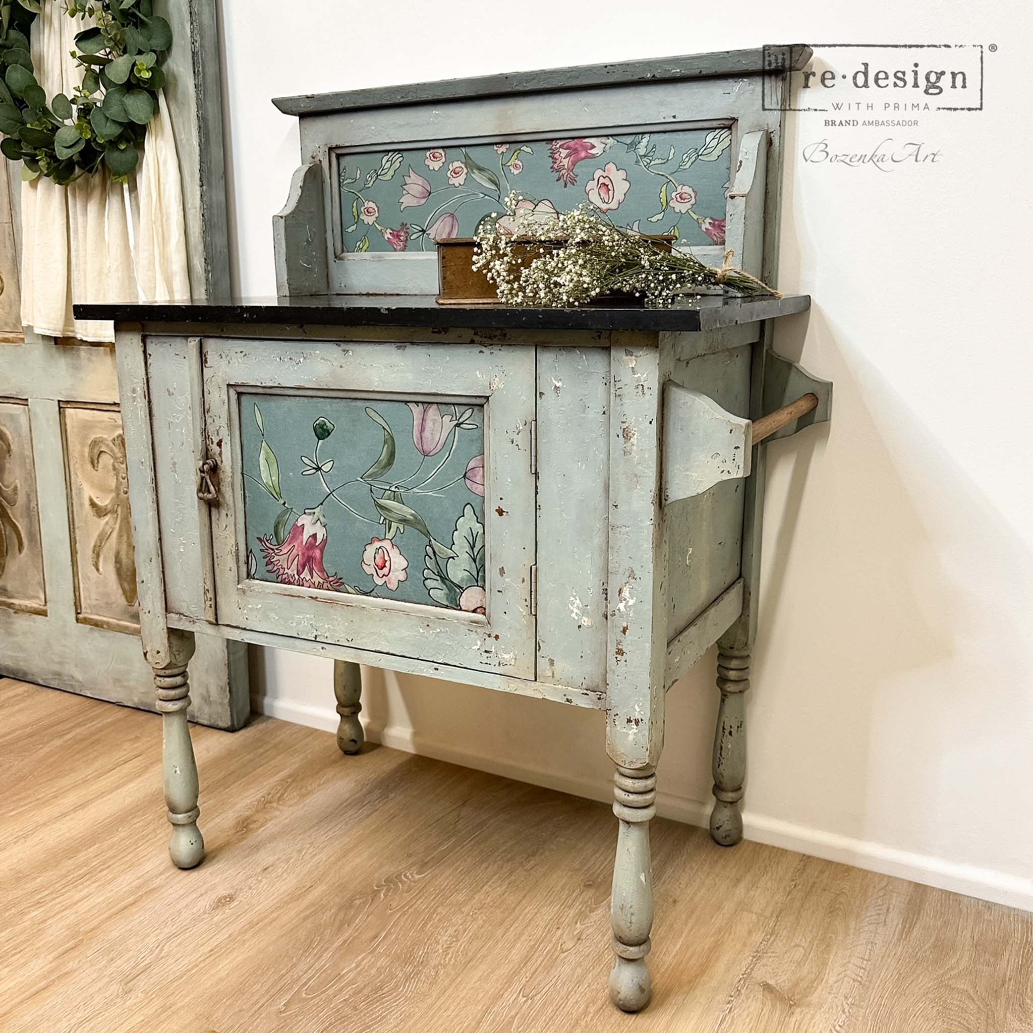 An angled view of a vintage bar cart table refurbished by Bozenka Art is painted light gray and features ReDesign with Prima's Swedish Posy A1 Fiber Paper by Annie Sloan on it.