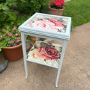 A side table with 1 shelf is painted  soft blue and features ReDesign with Prima's Salon de la Gloire A1 fiber paper on it.