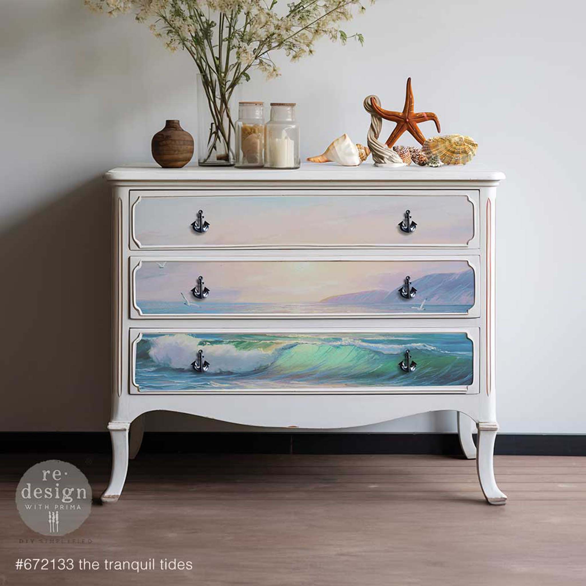 A vintage 3-drawer dresser is painted white and features ReDesign with Prima's Tranquil Tides A1 fiber paper on the drawers.