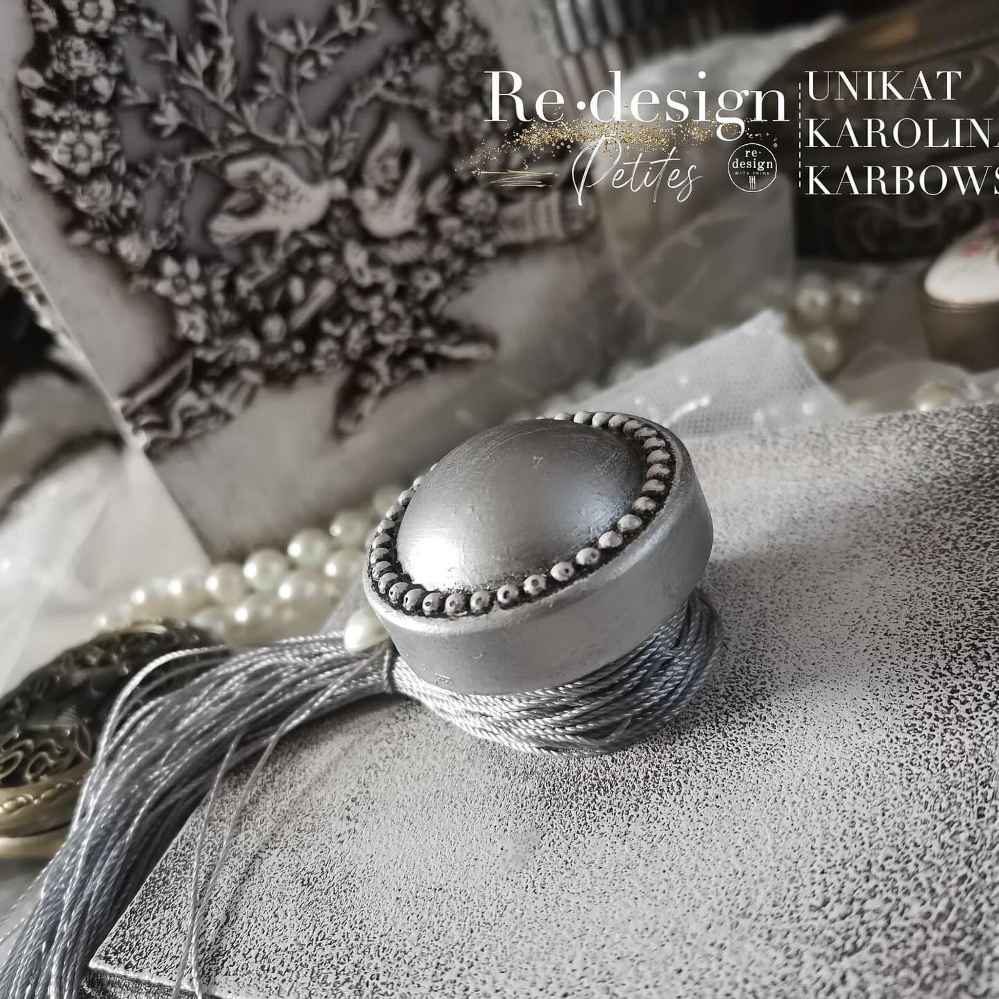 Close-up of a silver-colored, round, pearl-edged drawer knob created by Unikat Karolina Karbowska using ReDesign with Prima's Pearl Inlay 3D Knob silicone mold.