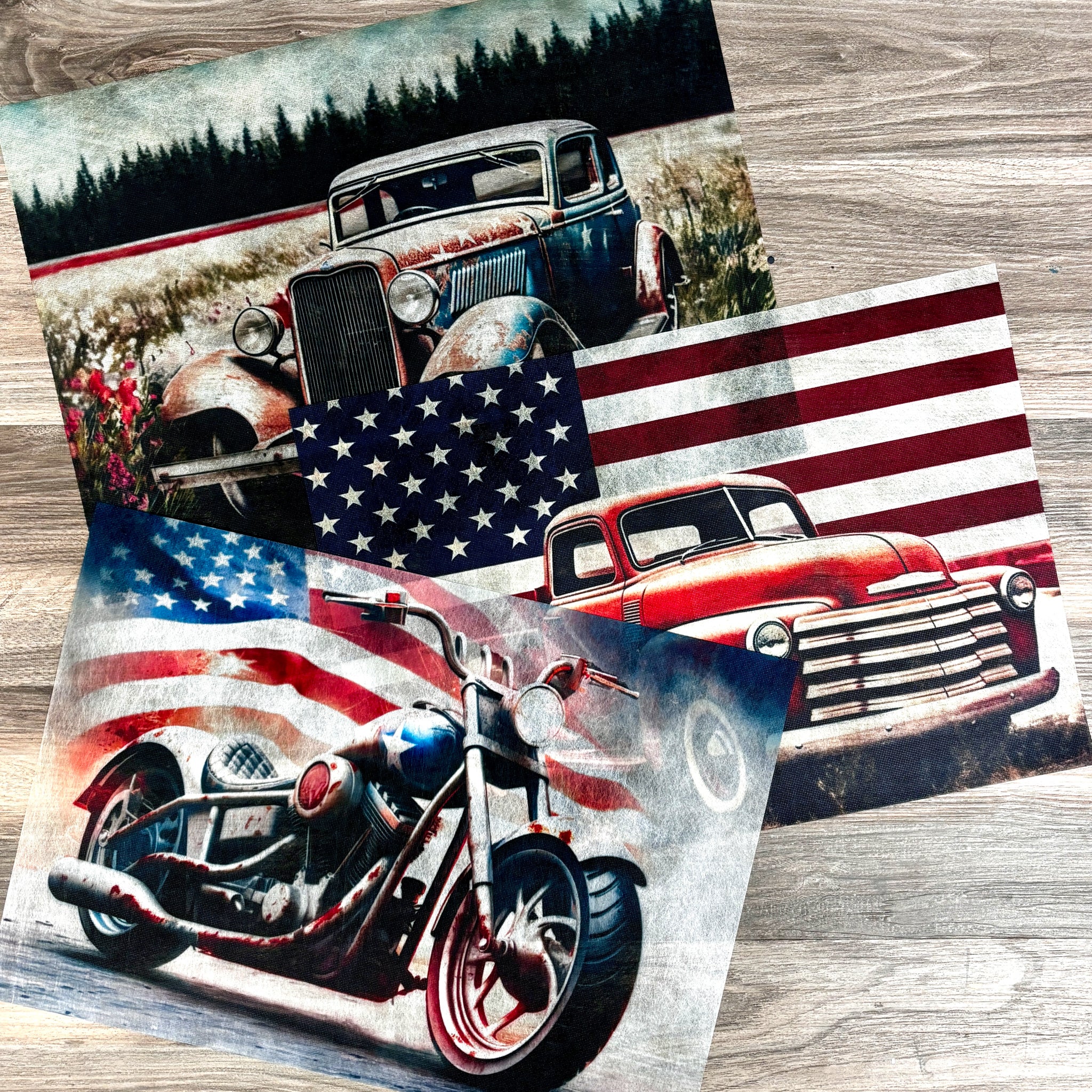 Three sheets of A3 fiber papers featuring vintage vehicles against American flags and 1 vehicle in an open field with a pine forest in the background are against a wood background.