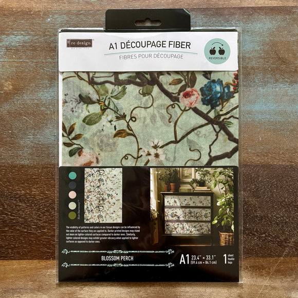 A package of ReDesign with Prima's Blossom Perch A1 fiber paper is against a wood background.