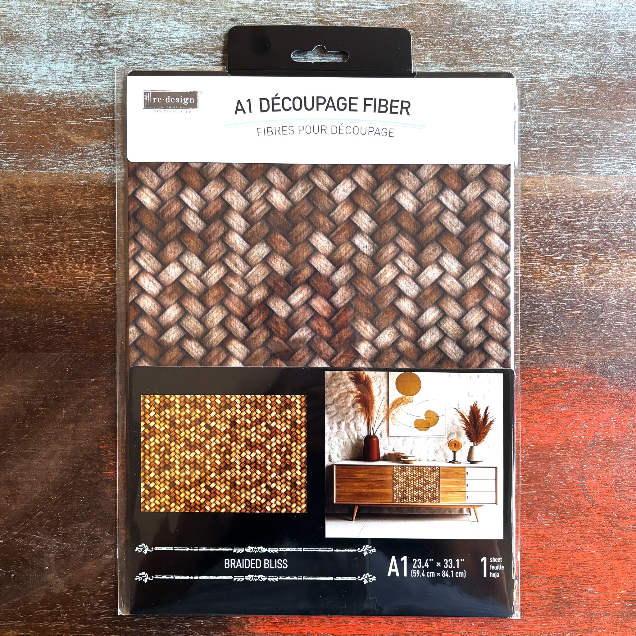 A package of ReDesign with Prima's Braided Bliss A1 fiber paper is against a dark wood background.