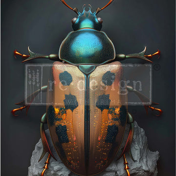 Close-up of an A1 fiber paper that features a metallic, jewel-toned design of a scarab beetle on a rock against a dark grey background.