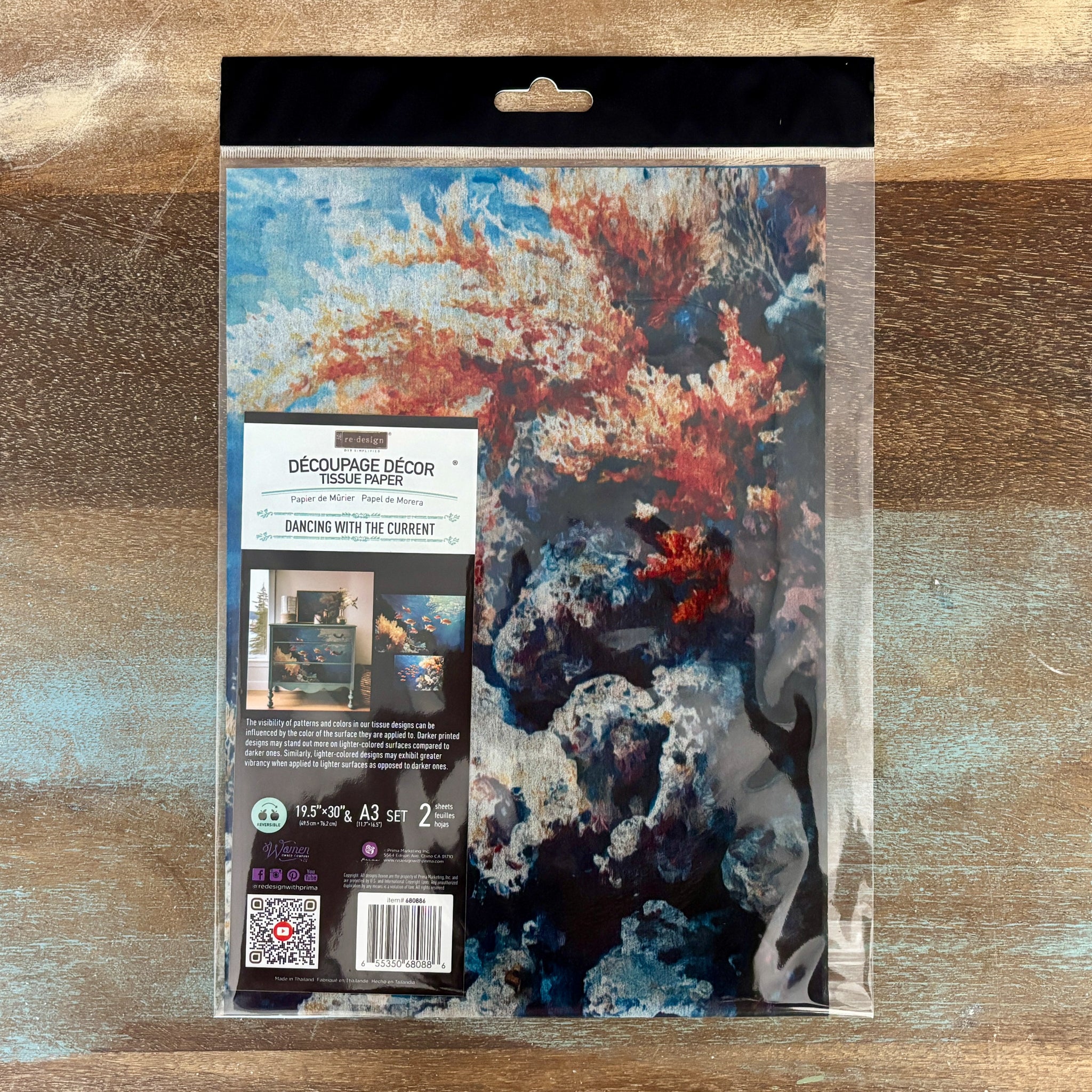 A package of ReDesign with Prima's Dancing with the Current Exclusive Fiber Paper Bundle is against a wood background.