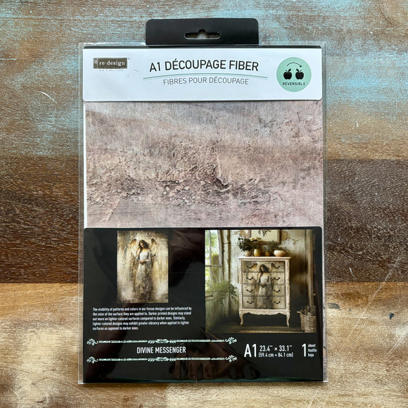 A package of ReDesign with Prima's Divine Messenger A1 Fiber Paper is against a wood background.
