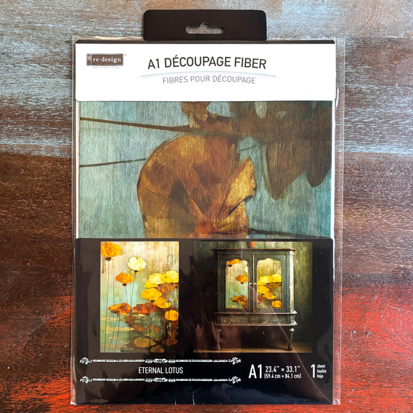 A package of ReDesign with Prima's Eternal Lotus A1 fiber paper is against a dark wood background.