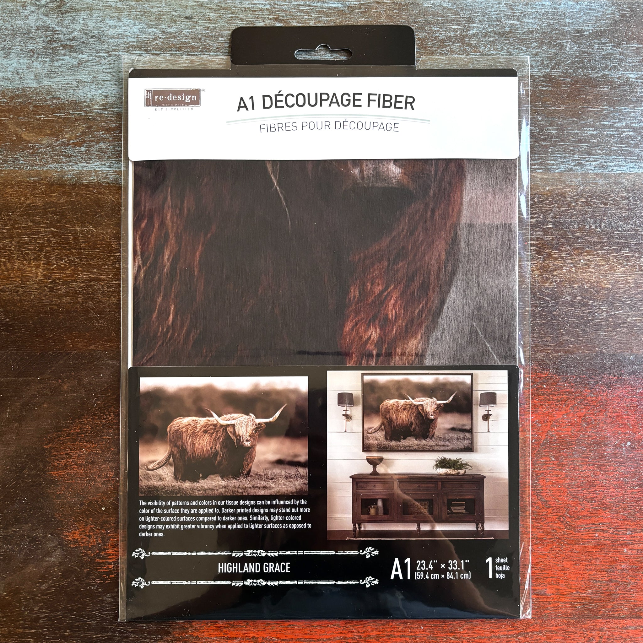 A package of ReDesign with Prima's Highland Grace fiber paper is against a dark wood background.