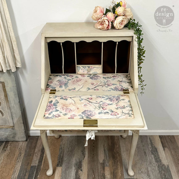 A vintage secretary's desk is painted cream color and features ReDesign with Prima's Kacha Timeless Blooms fiber paper inside the drop down door and on the desktop.