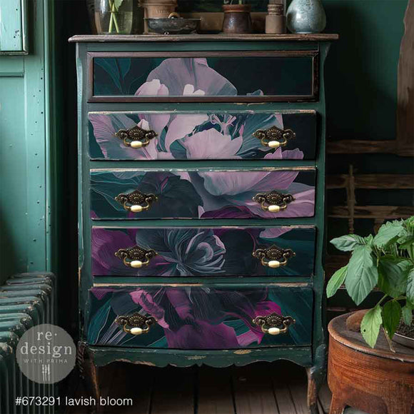 Furniture with floral design on drawers against a dark green wall.