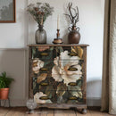 Wooden cabinet with floral design on a wooden floor, decorated with vases and a candle.