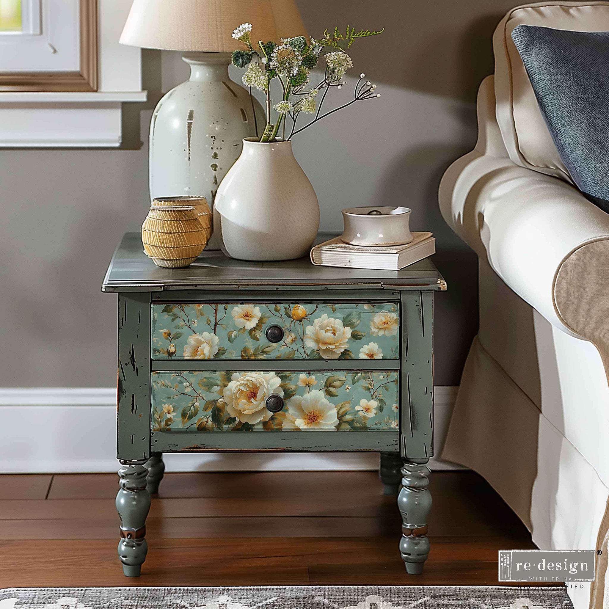 A small 2-drawer end table with weathered grey paint features ReDesign with Prima's Pure Petal Elegance on the drawers.