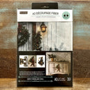 A package of ReDesign with Prima's Santa's Woodland Stroll A3 fiber paper 3 pack is against a wood background.