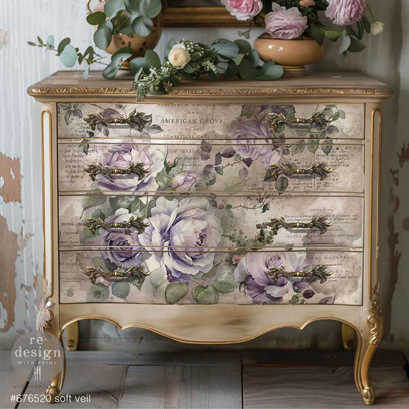 A vintage drawer chest dresser is painted soft beige with gold accents and features ReDesign with Prima's Soft Veil Fiber paper on the drawers.