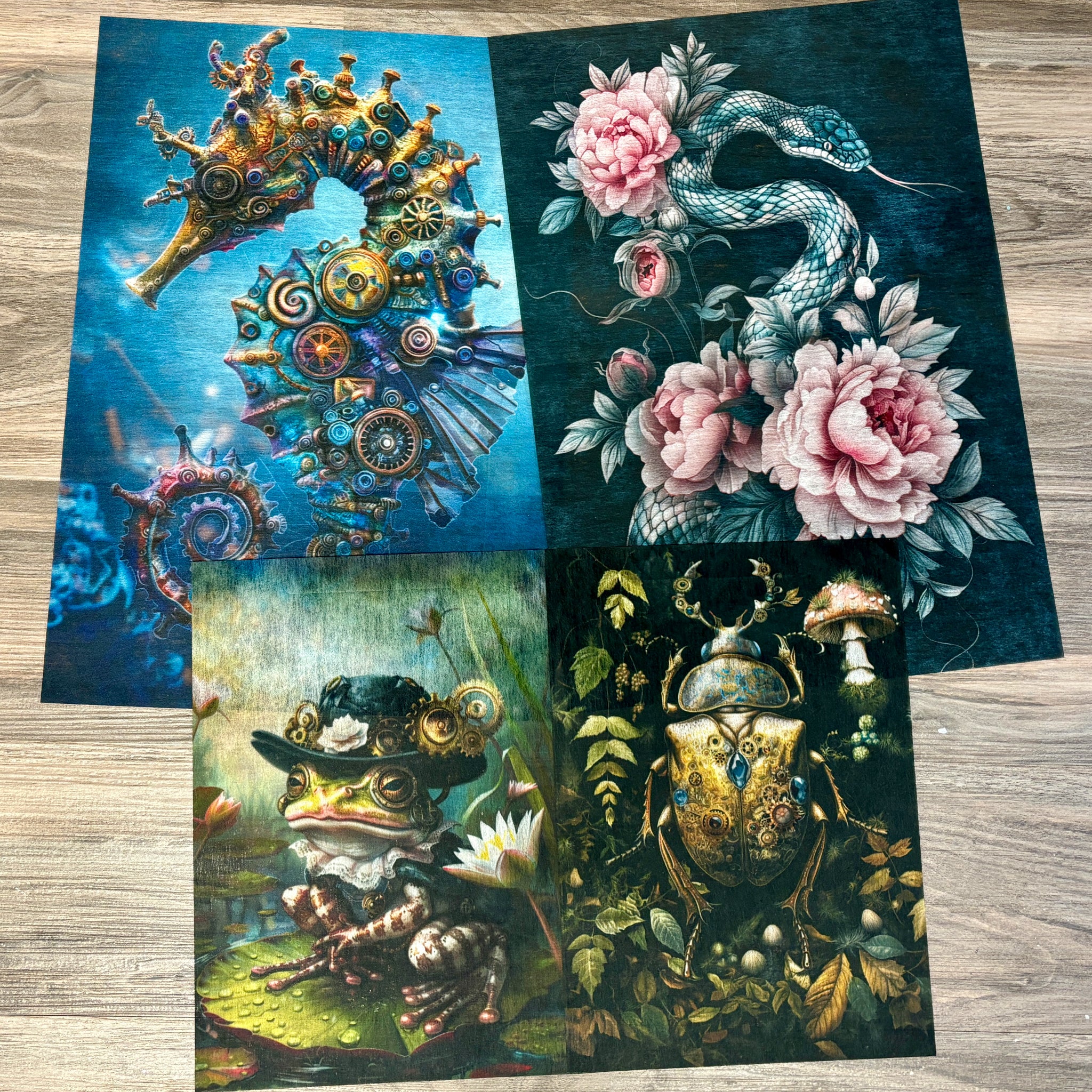 Three sheets of A3 fiber papers featuring 3 designs of a steampunk style seahorse, frog, and beetle, and 1 design of a snake with pink flowers are against a light wood background.