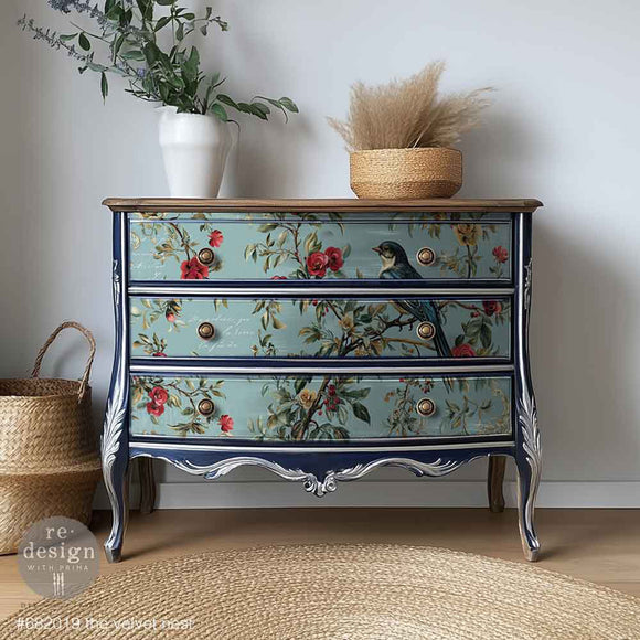 Decorative chest of drawers with floral design against a neutral wall.