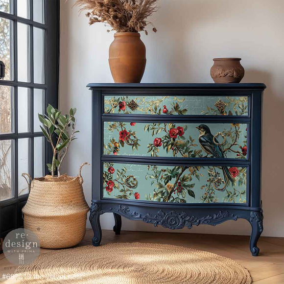 Decorative dresser with floral and bird design on drawers in a room setting.