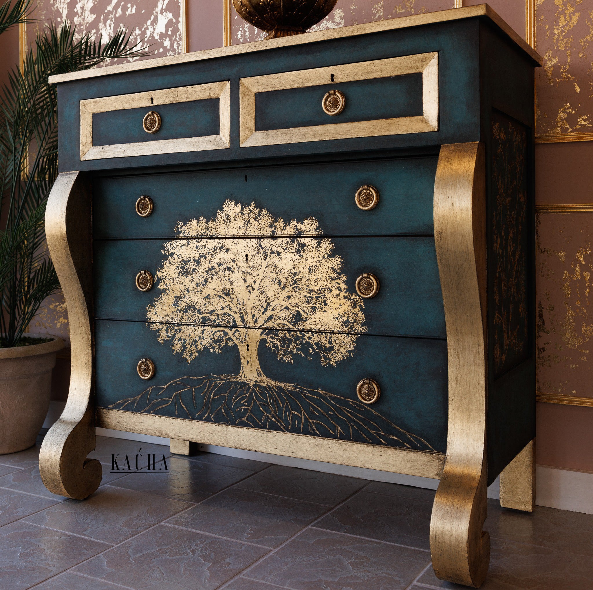 A vintage 5-drawer dresser refurbished by Kacha is painted dark teal blue with gold accents and features ReDesign with Prima's Kacha Growth Gold Foil rub-on transfer on the bottom 3 drawers.