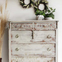 A dresser is painted a distressed white and features the Gorgeous Coral Flora small H2O transfer on it.