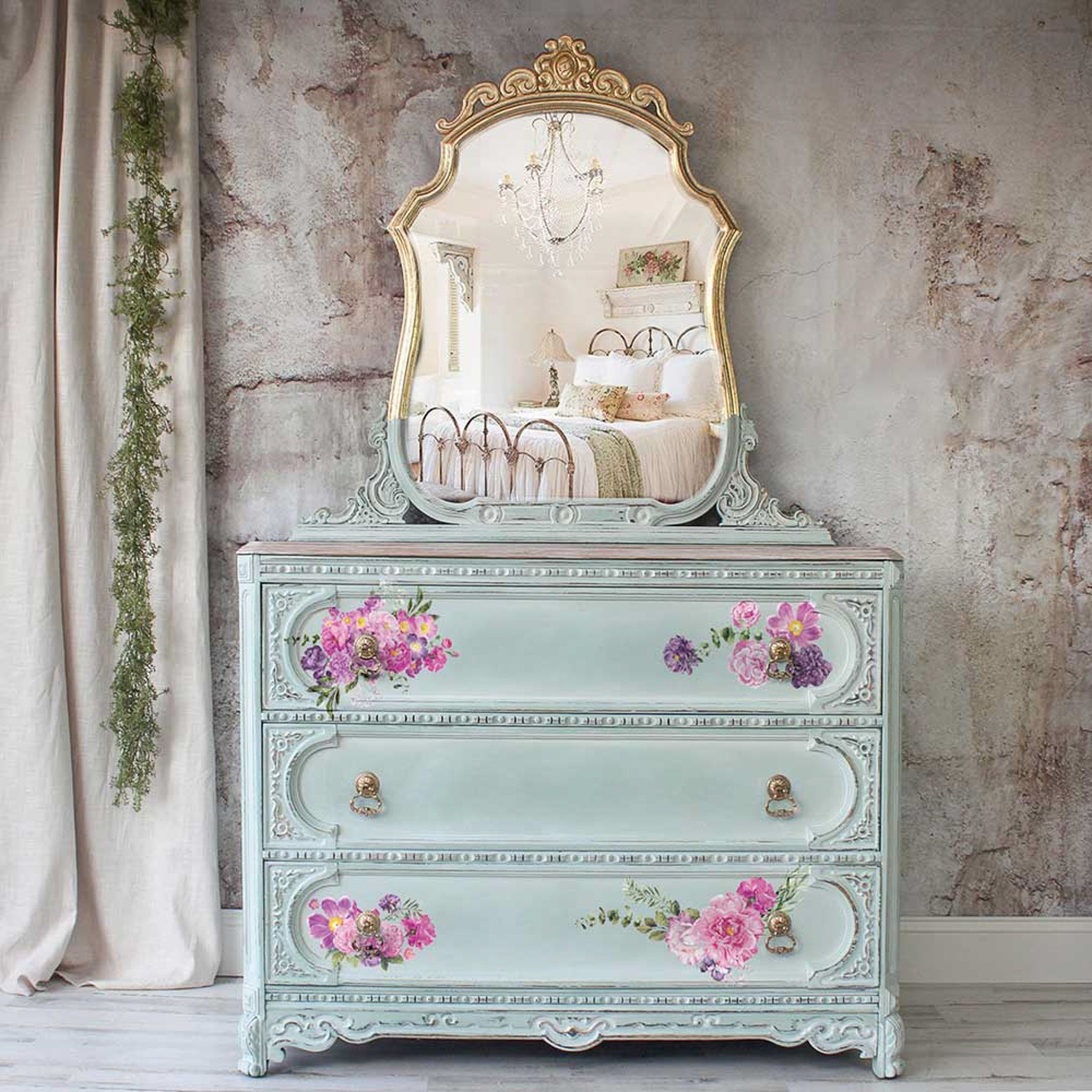 A vintage dresser is painte pale blue and features ReDesign with Prima's Purple Blossom small transfer on its drawers.