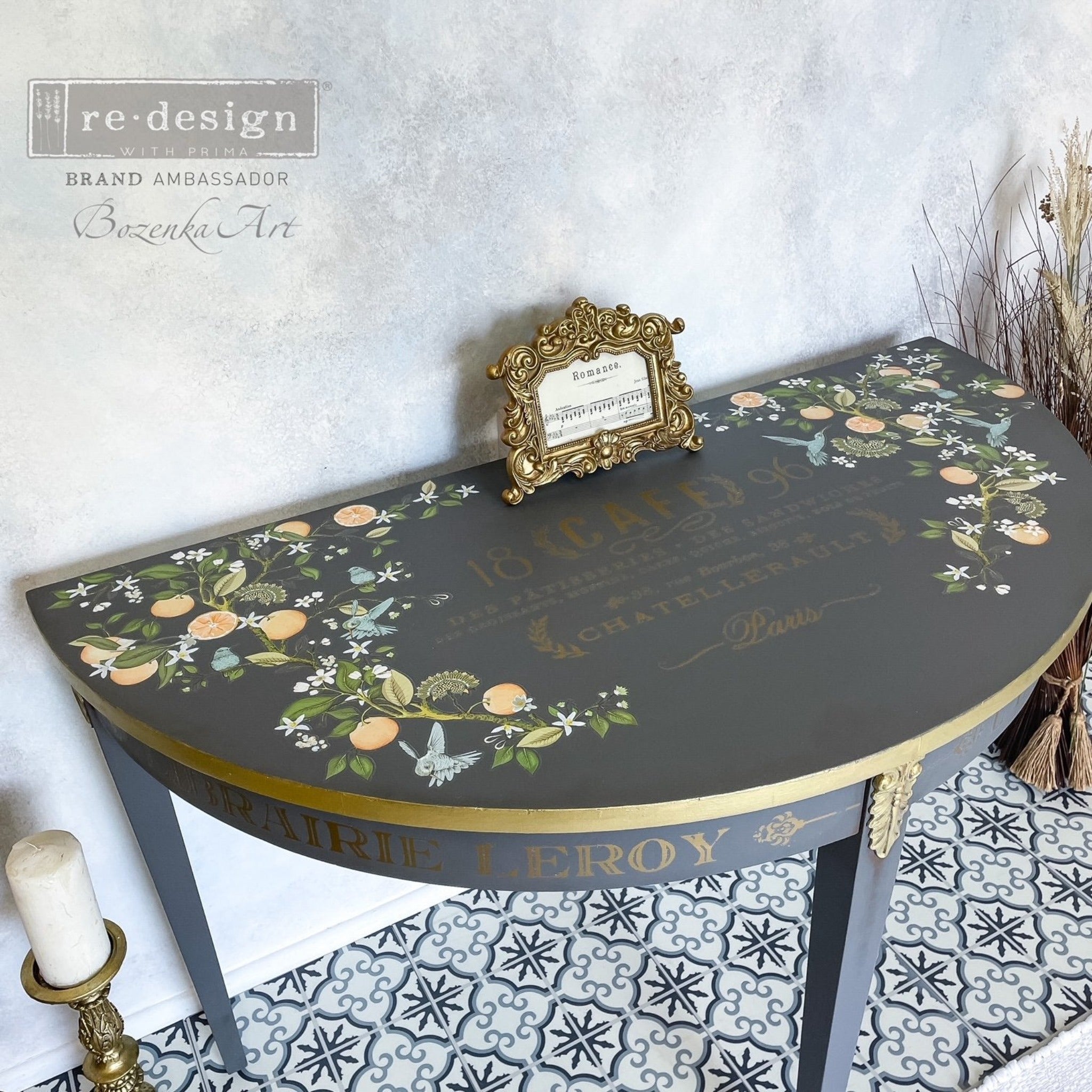 A half circle entryway table refurbished by Bozenka Art is painted medium grey with gold accents and features ReDesign with Prima's Orange Grove transfer on the top.