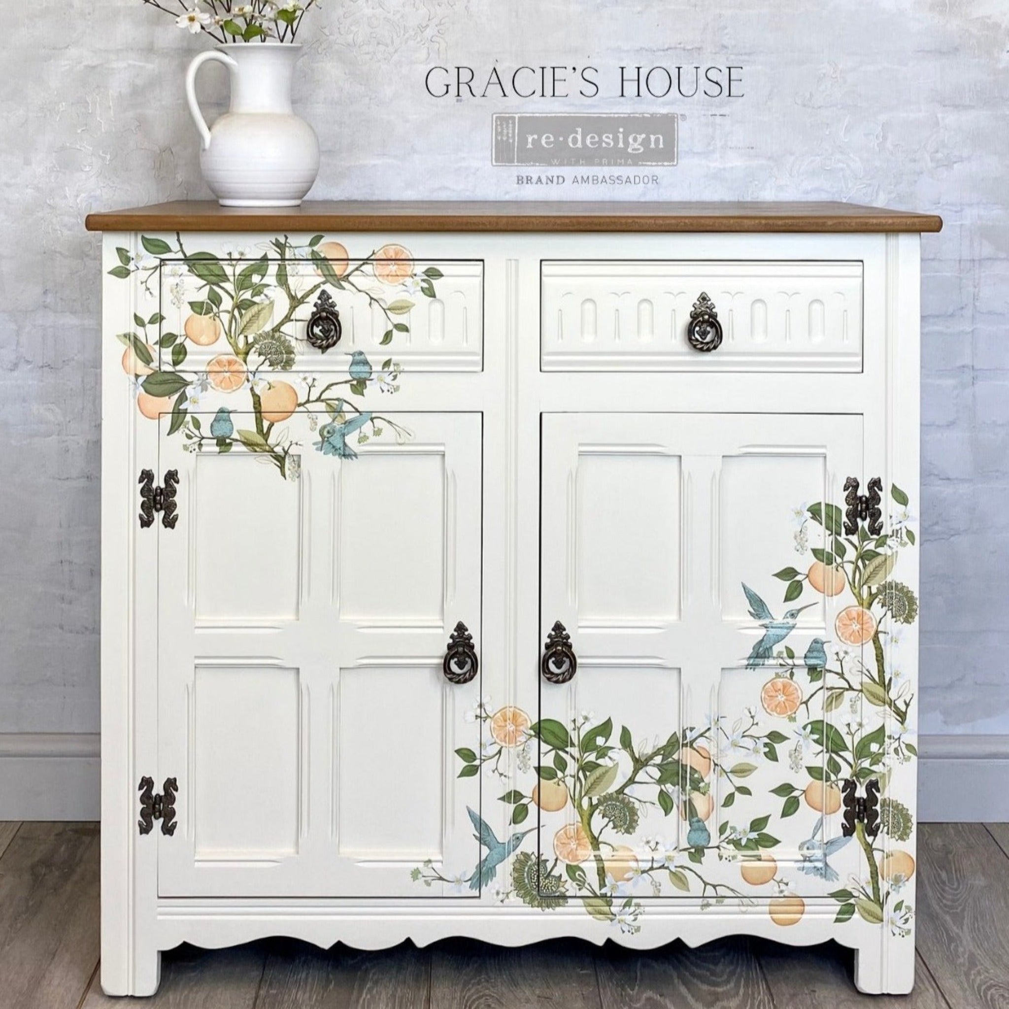 A small buffet cabinet refurbished by Gracie's House is painted soft white and features ReDesign with Prima's Orange Grove transfer on the front.