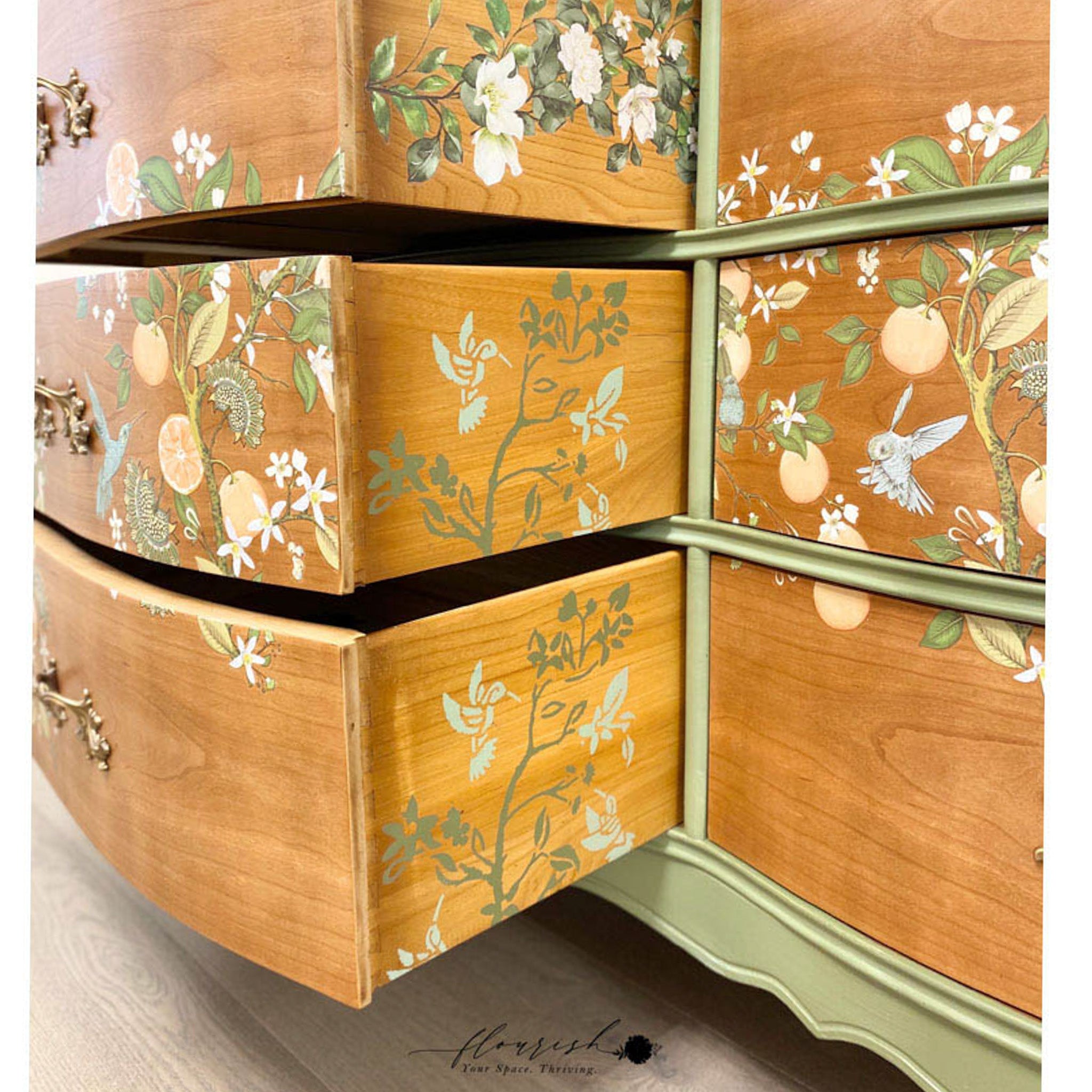 A close-up of a vintage 6-drawer dresser refurbished by Flourish Your Space Thriving features ReDesign with Prima's Orange Grove transfer on natural wood drawers.