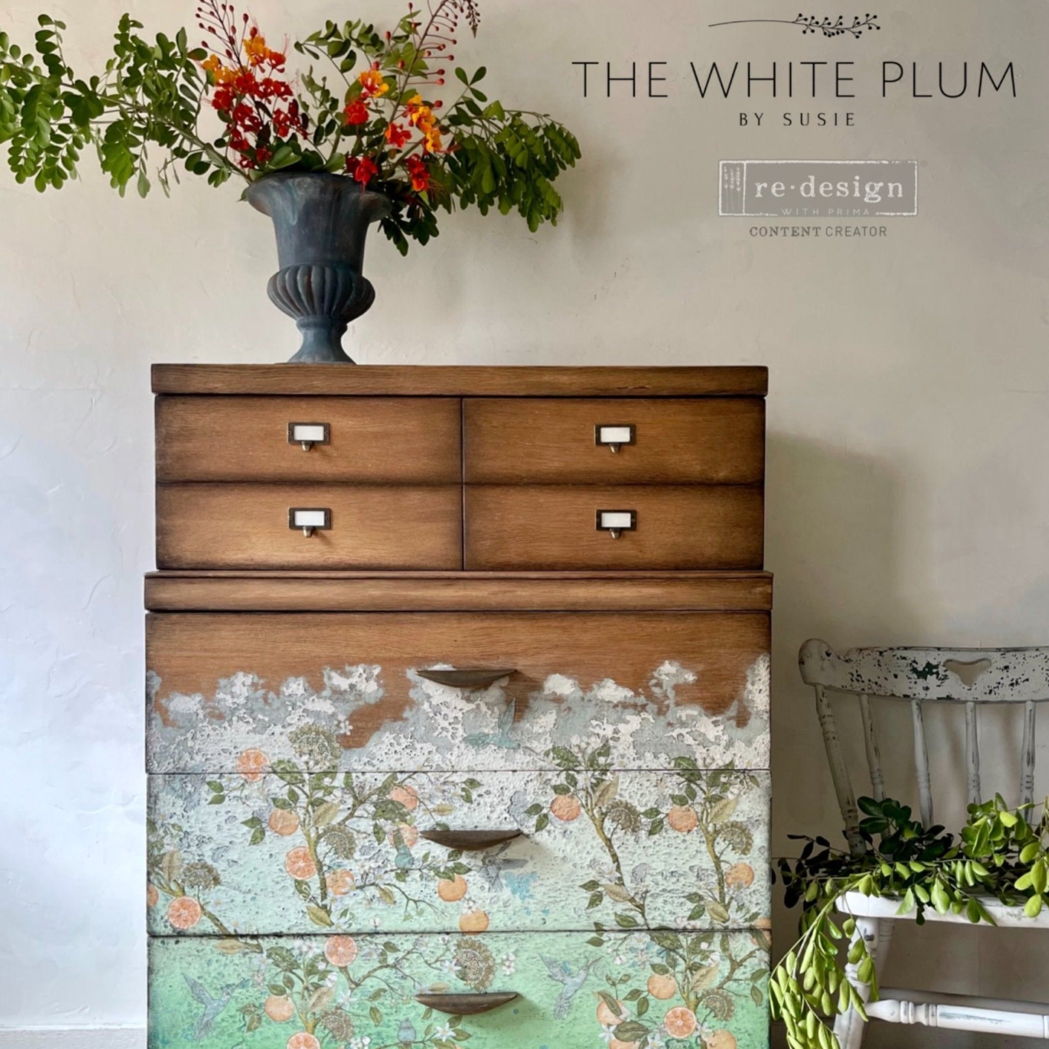 A vintage 7-drwer chest dresser refurbished by The White Plum by Susie is natural wood and features ReDesign with Prima's Orange Grove transfer against some white weathered paint on the bottom 3 drawers.