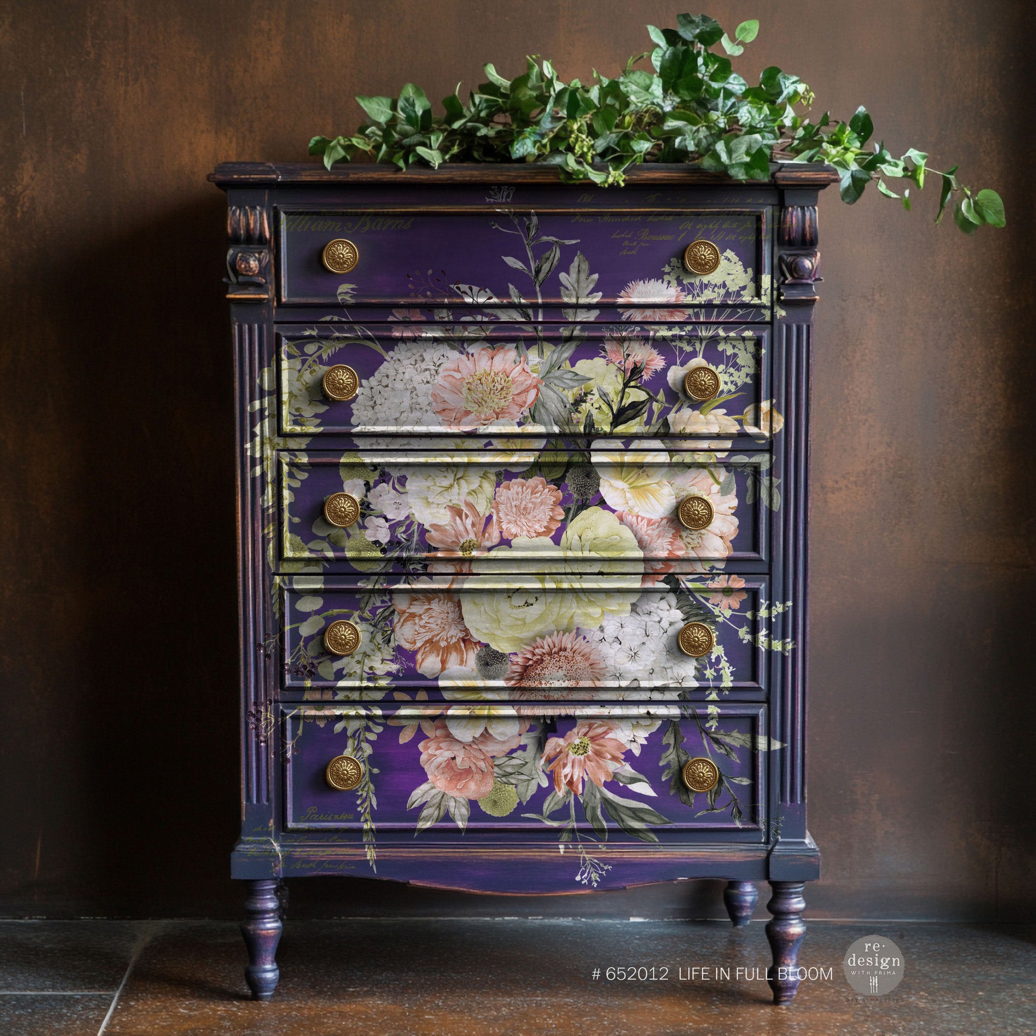 A vintage 5-drawer chest dresser is painted royal purple and features ReDesign with Prima's Life in Full Bloom rub-on transfer on the front.