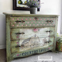 A vintage large 3-drawer dresser is painted a light green grungy color and features ReDesign with Prima's Out on the Farm transfer on its bottom 2 drawers.