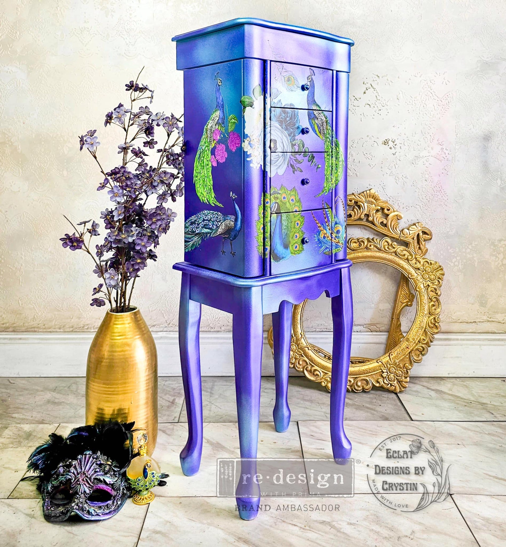 A vintage 4-drawer standing jewelry armoire refurbished by Eclat Designs by Crystin is painted a blend of blue and purple and features ReDesign with Prima's Peacock Dreams transfer on it.