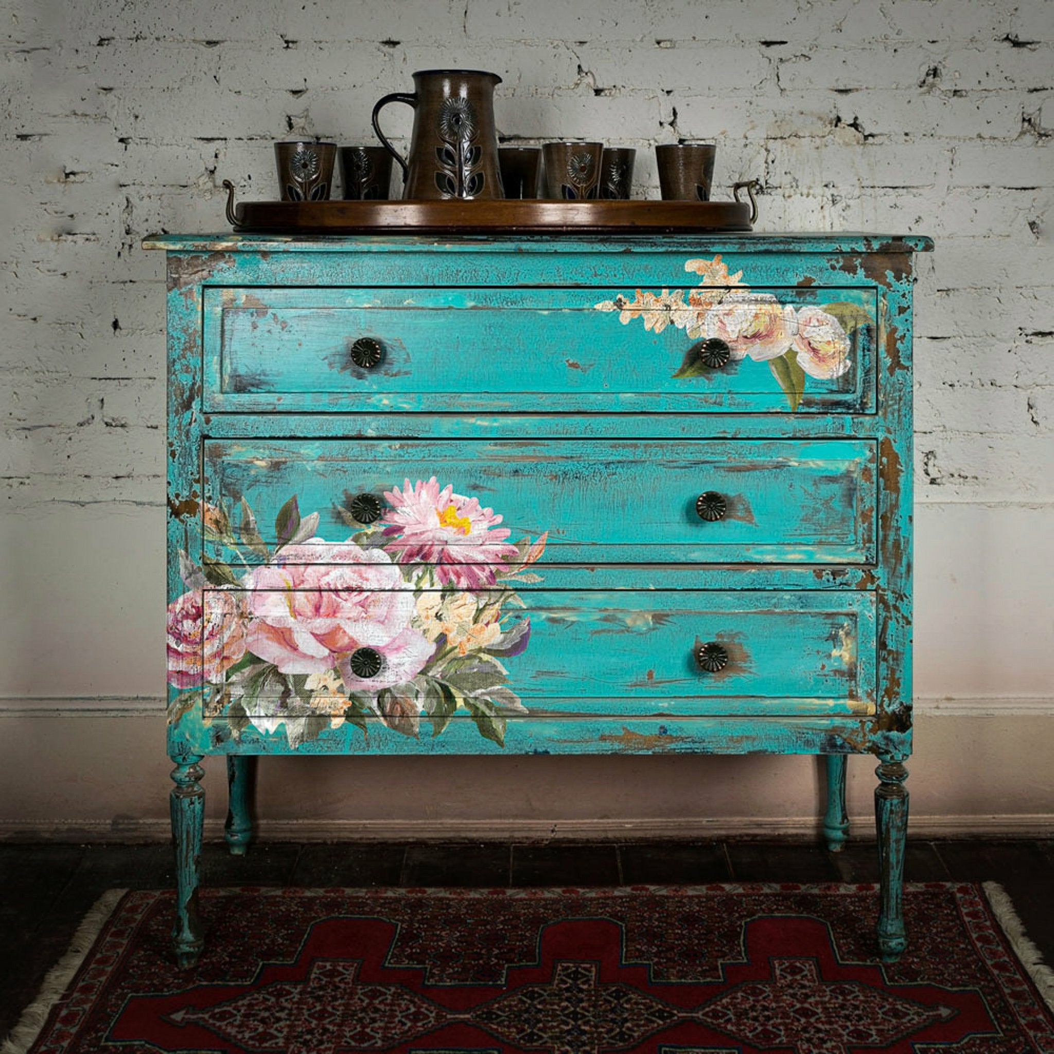 A vintage 3-drawer dresser is painted bright teal blue and features ReDesign with Prima's Rose Quartz transfer on the front.