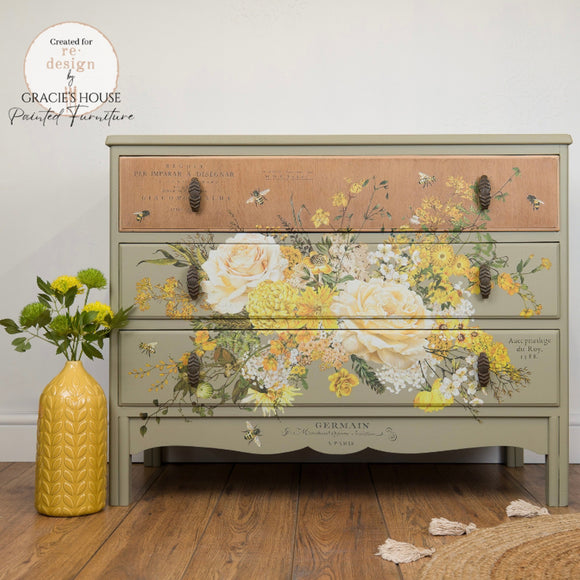 Full dresser mockup featuring the Sunlit Serenade furniture transfer by ReDesign with Prima across the center drawers—creamy roses, golden blooms, French script, and bees—styled with a yellow vase on a wood floor