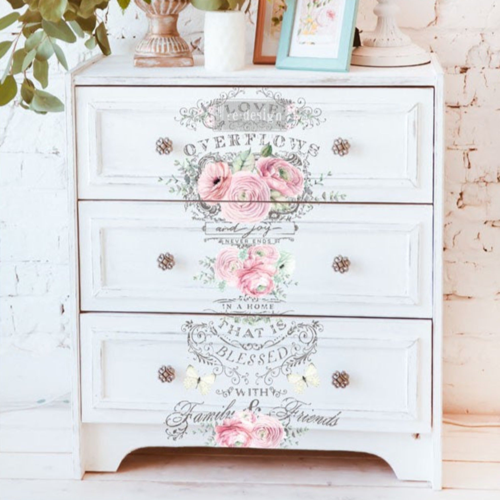 A vintage 3-drawer dresser is painted white and features ReDesign with Prima's Overflowing Love transfer on the front.