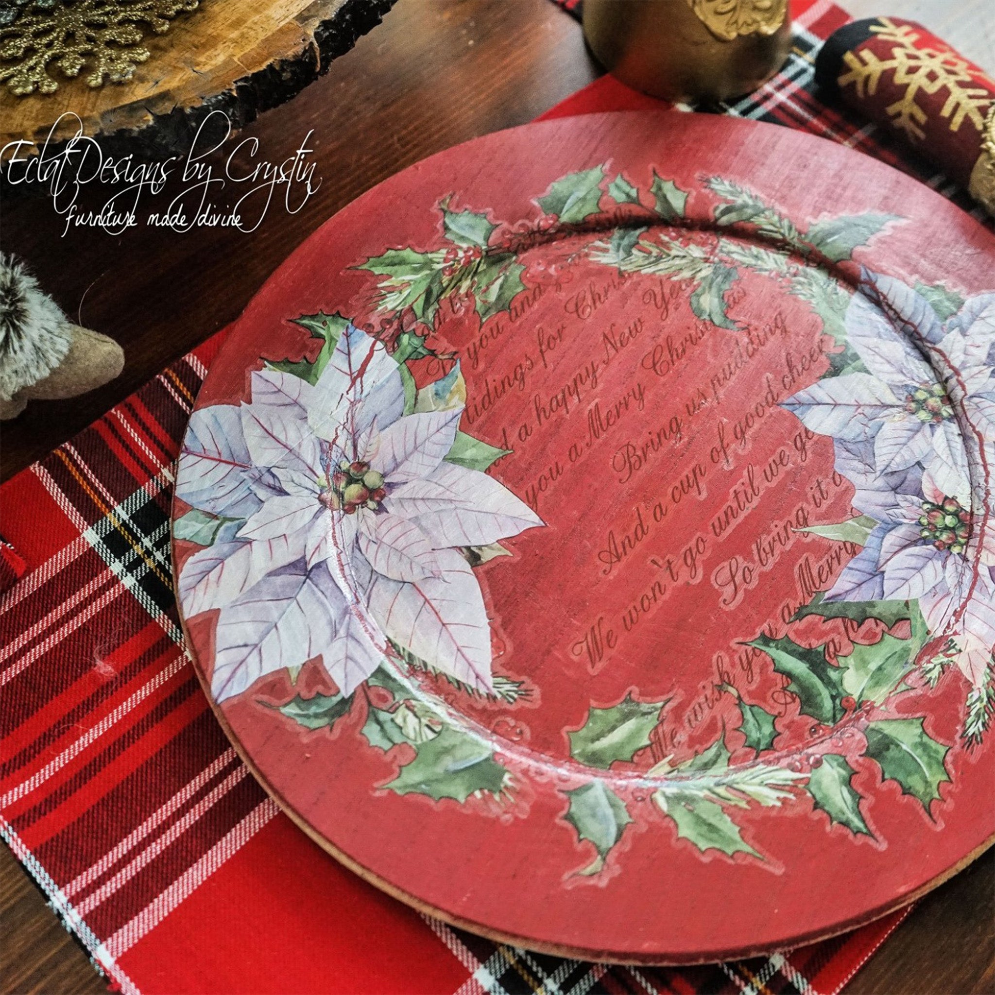 ReDesign with Prima's Paulownia Wood Charger is painted red and has a transfer of white poinsettia flowers on it