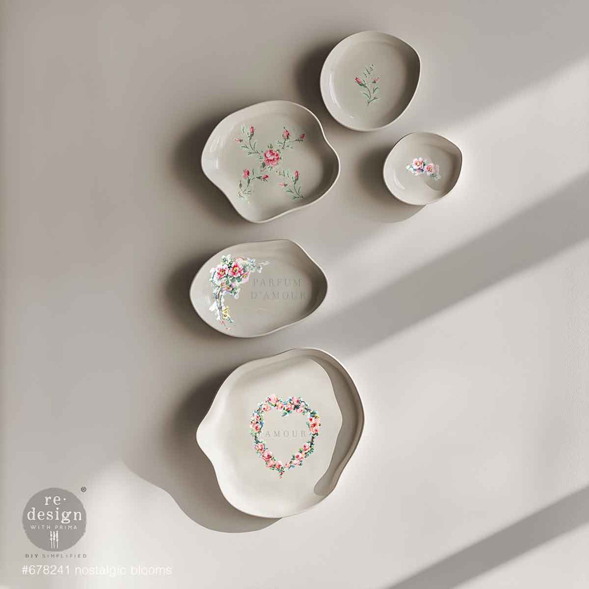 Five uniquely shaped varying size white bowls feature ReDesign with Prima's Nostalgic Blooms H2O Water Transfers inside the bowls.