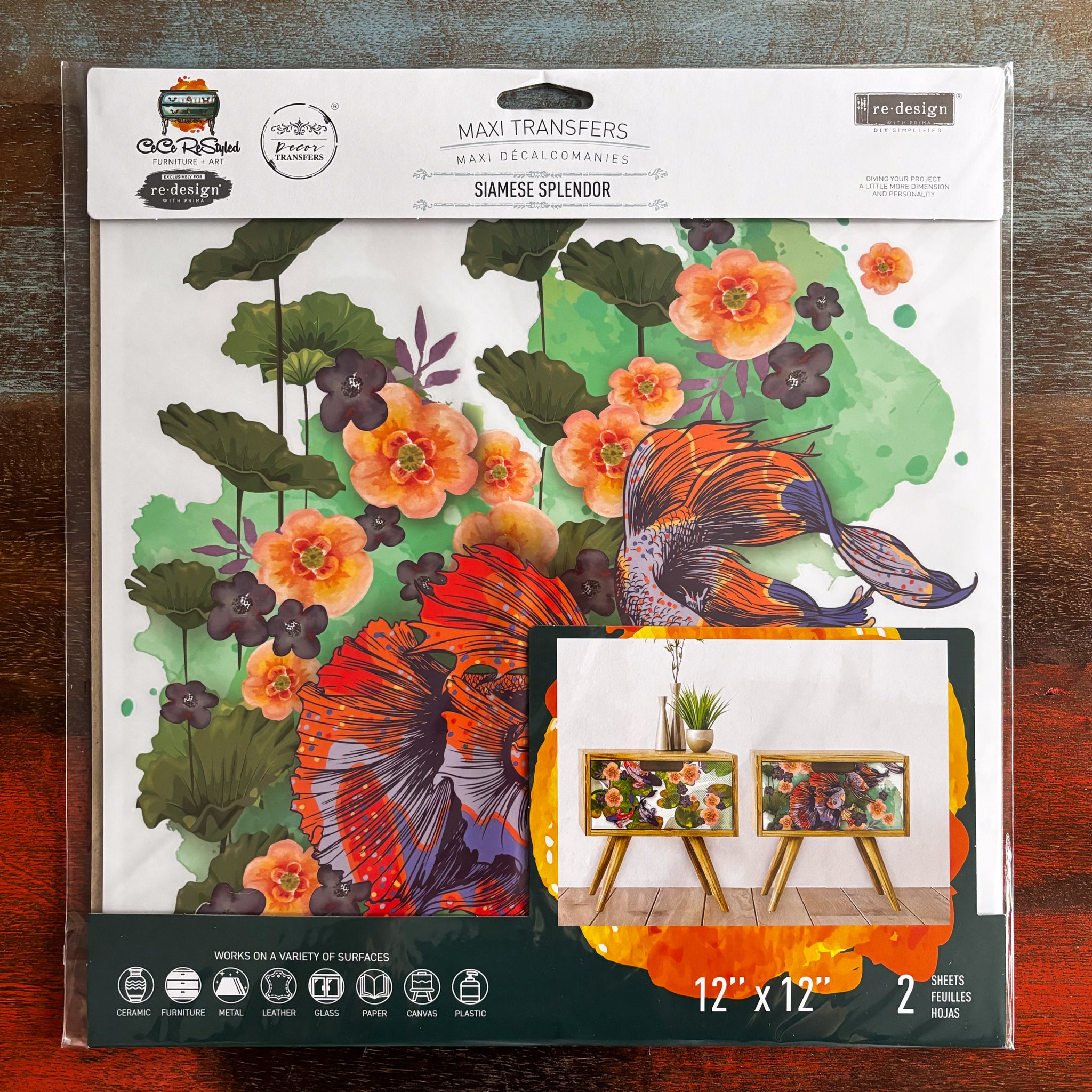 A package of ReDesign with Prima's Siamese Splendor 12" x 12" transfer is against a dark wood background.