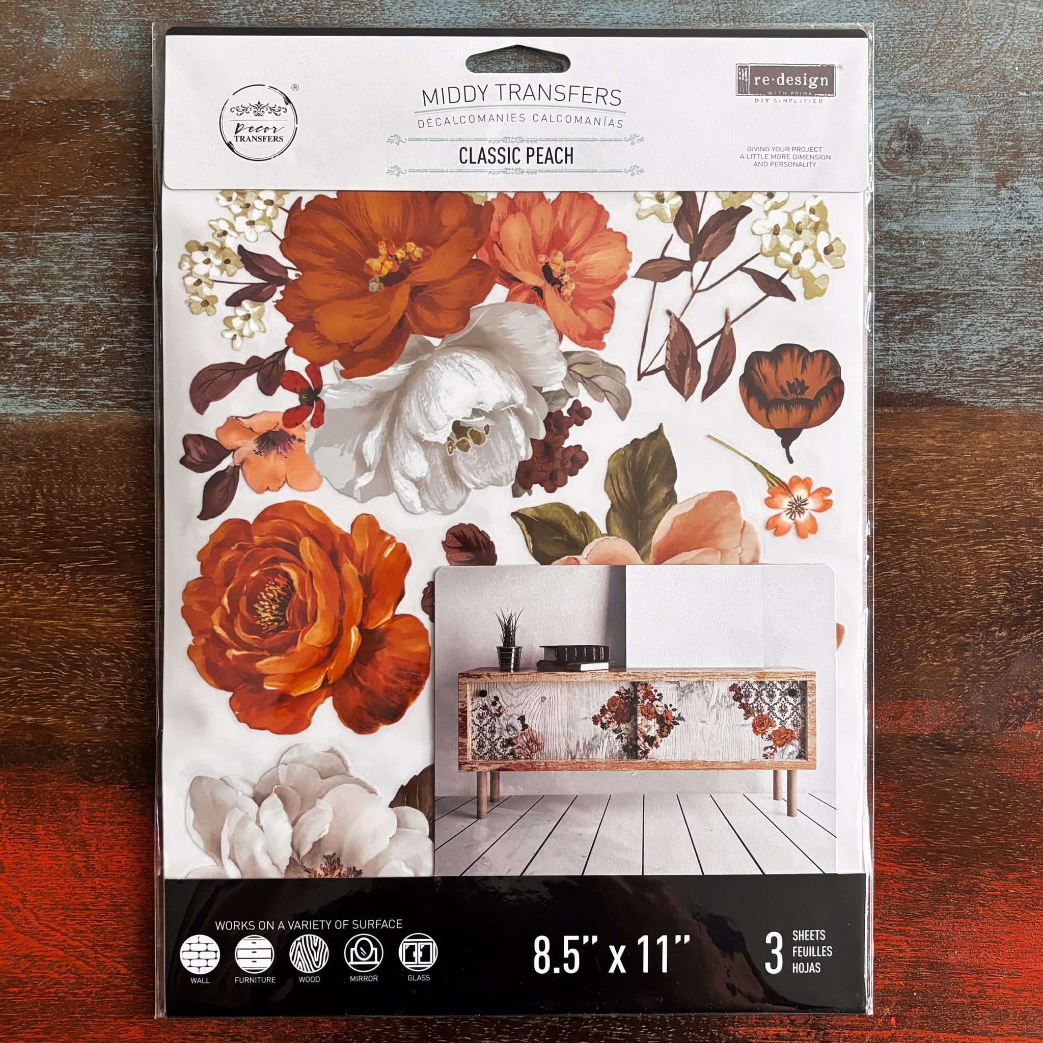 A package of ReDesign with Prima's Classic Peach small transfer is against a dark wood background.